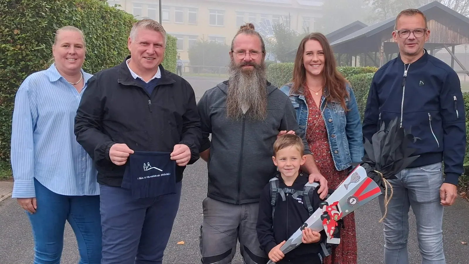 „I bin a Hirschauer Stückl” – so steht es auf den Loop-Schals, mit denen sich die 33 Abc-Schützen der Hirschauer Grundschule künftig vor Wind und Kälte schützen können. Spendiert wurden ihnen die Schals vom CSU-Ortsverband Hirschau und dem FU-Ortsverband. Von links.: CSU-Stadträtin Michaela Meier, CSU-Stadtrat Martin Merkl, Papa und FW-Stadtrat Stefan Enderer, Mama Sandra Enderer und 3. Bürgermeister Hermann Gebhard. Vorne: ABC-Schütze Ludwig Enderer. (Bild: Regina Merkl)