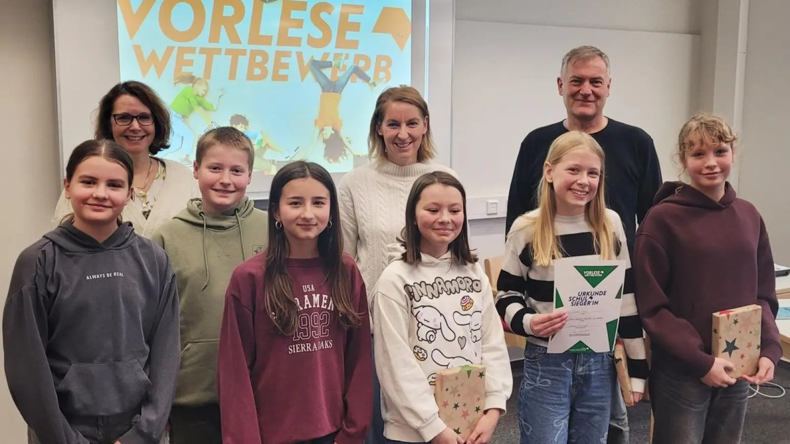 Die drei schulbesten Vorleserinnen des Nabburger Gymnasiums waren in diesem Jahr Sarah Hösl (2.v.r.), Ariane Pösl (Mitte) und Elisa von Stern (rechts). Sie wurden im Namen des Elternbeirats mit Buchpreisen ausgezeichnet, die das Buchcafé Pfreimd zur Verfügung stellt. Ebenfalls mit einer Urkunde ausgezeichnet wurden die weiteren Klassensieger*innen. Schulleiter Christian Schwab (hinten rechts) gratulierte gemeinsam mit den beiden Jurorinnen Petra Giebisch (hinten links) und Karin Wilnauer (hinten Mitte) zu dieser besonderen Leistung. (Bild: Andreas Fröhlich)