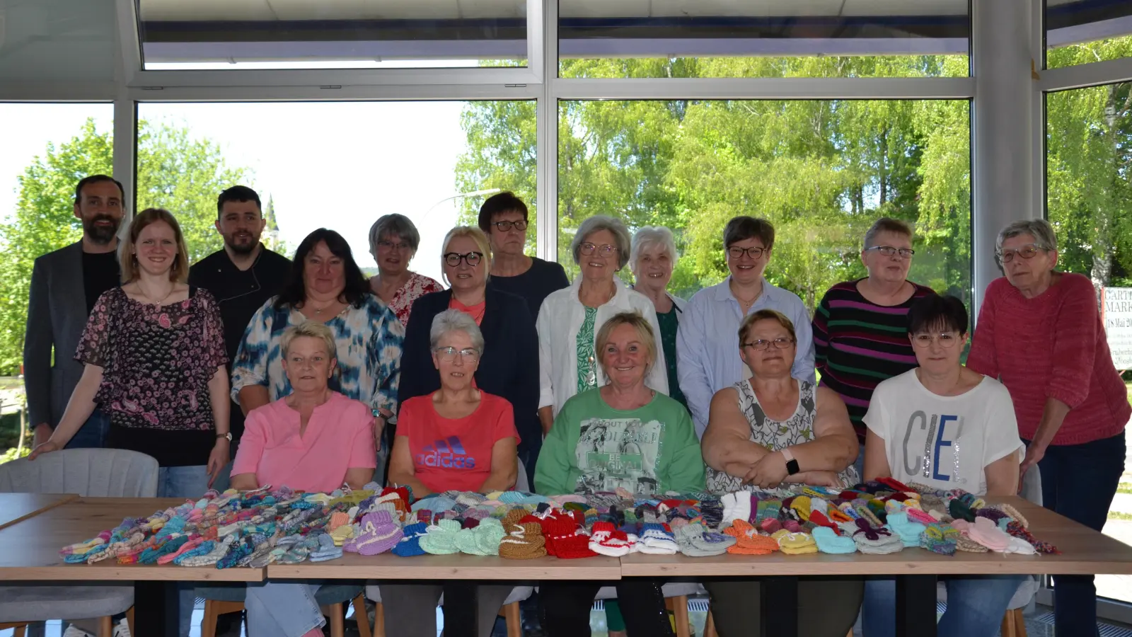 300 Babymützchen und –söckchen übergaben die Strickerinnen den Gesamtschwerbehinderten-Vertreterinnen Dani Kollmann und Burgi Zielbauer (stehend Vierte und Sechste von links) für das Klinikum Weiden, Station 32 der Entbindungsstation. Dazu gratulierten Bürgermeister Armin Bulenda sowie Eva und Julian Wurdack (von links).<br><br> (Bild: Peter Garreiss)