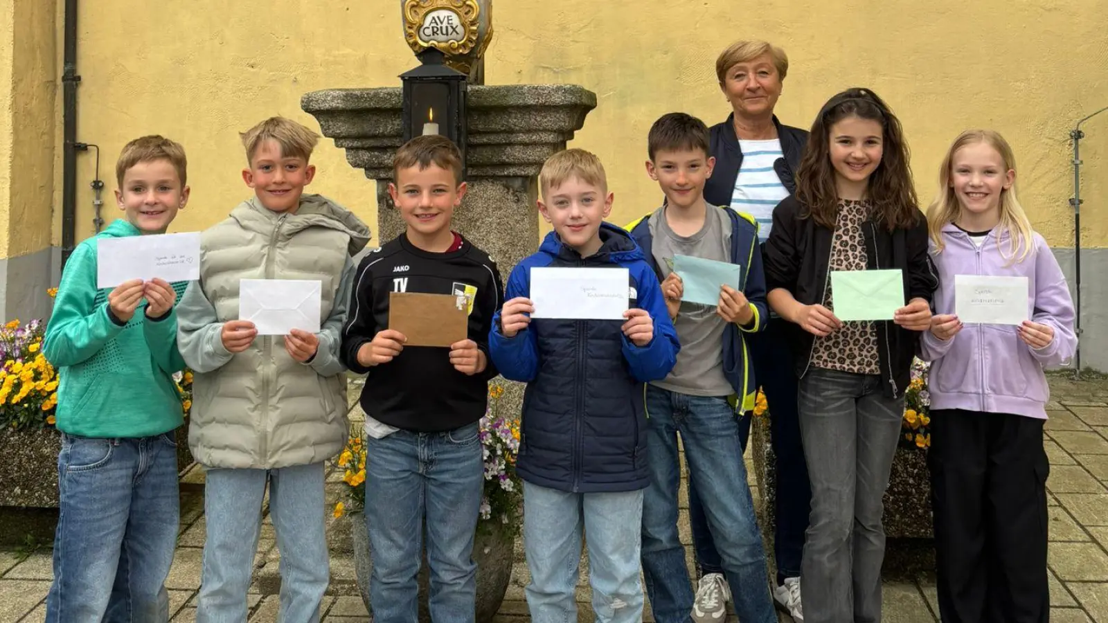 Acht Neustädter Erstkommunionkinder zeigen ein Herz für kranke Kinder und spenden 850 Euro an die Kinderkrebshilfe Oberpfalz Nord. Für die nahm Petra Troppmann (Dritte von rechts) die Spende dankbar entgegen. (Bild: Kerstin Heß)