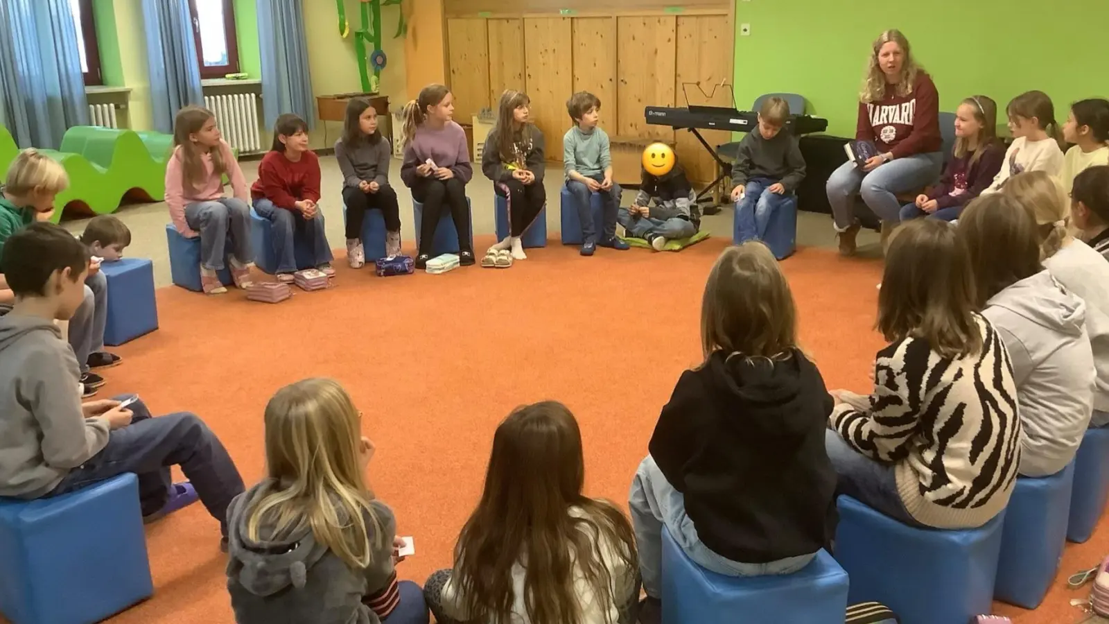 Kinder der 3. und 4. Jahrgangsstufe lauschen Elena Harwardt beim Vorlesen von „Momo”. (Bild: Sabine Wildenauer)