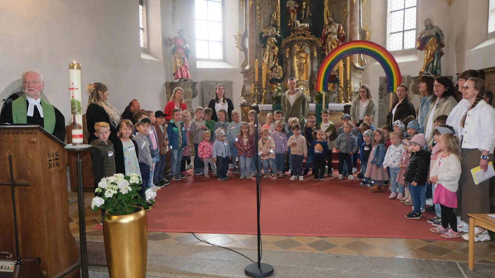Unter dem großen Transparent des Regenbogens erfreuten die Kinder des Kindergartens „Unterm Regenbogen“ mit dem Lied“ Wo zwei oder drei in meinem Namen zusammen sind“. (Bild: Fred Lehner)