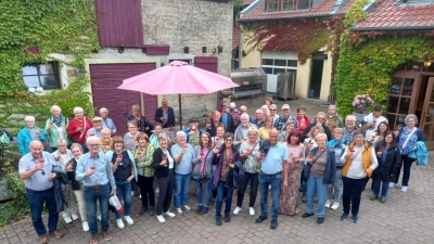 Prost! Begrüßung der Rosenberger Siedler in Handthal mit Winzerin Barbara Baumann (vordere Reihe Mitte, hellblaues Shirt) (Bild: Werner Singer)