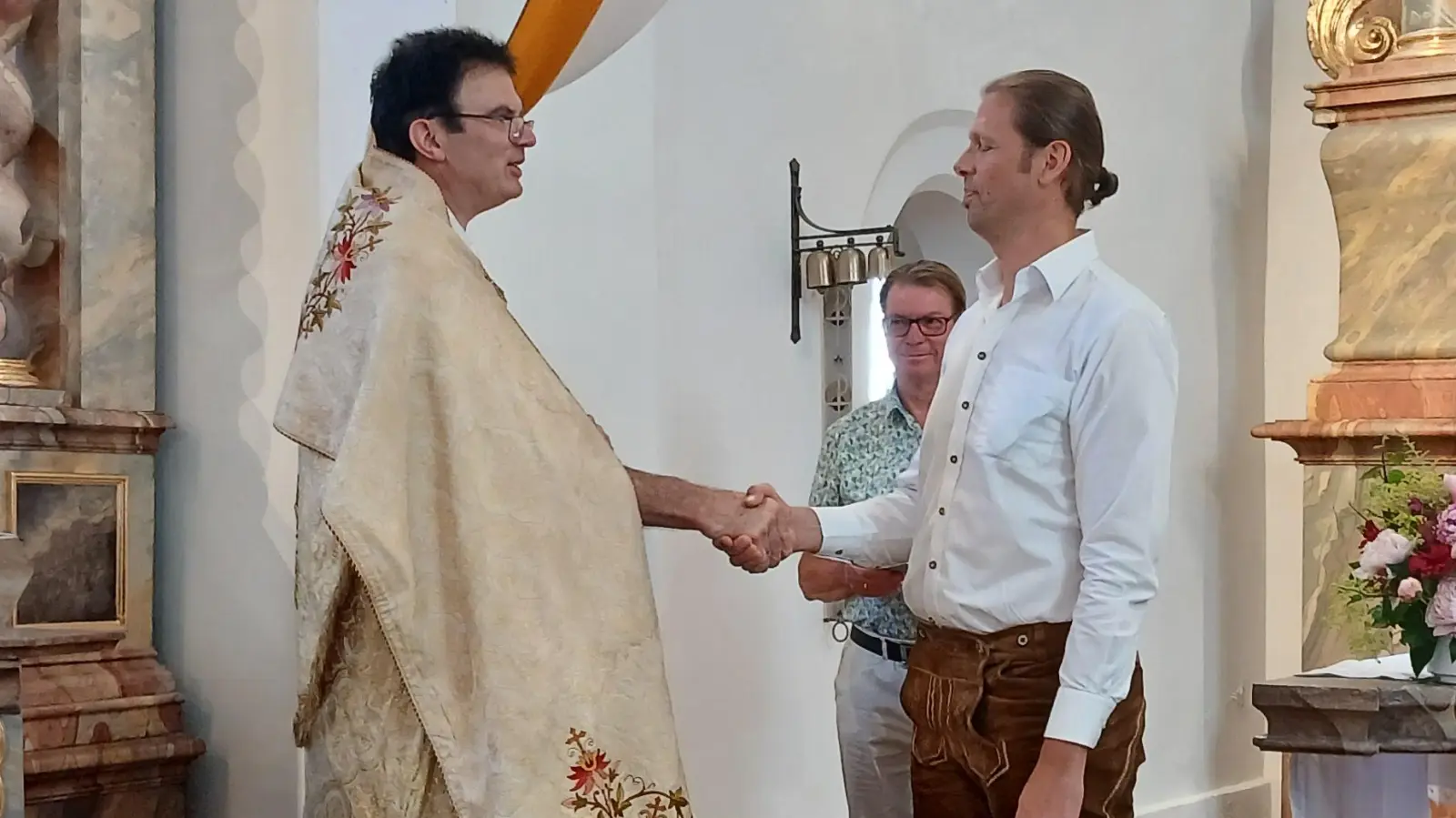 Pfarrer Wolfgang Dietz bedankt sich bei Chorleiter Alexander Lottner für 10-Jahre Dienst (Bild: Silvia Bindl-Ostermayr)