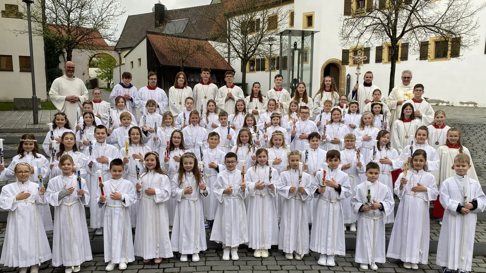 Gruppenbild der Erstkommunionkinder, den Ministranten, Pfarrer Hannes Lorenz (oben rechts) und Gemeindereferent Thomas Kern (oben links). (Bild: Raphael Haubelt)