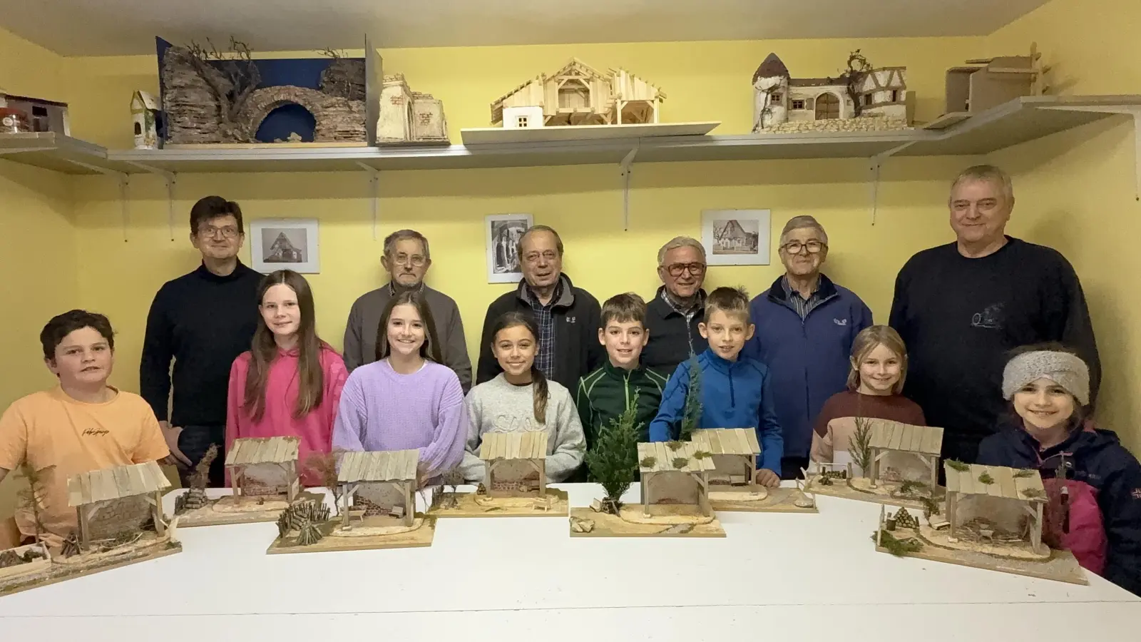 Auf dem Bild von links nach rechts vorne: Die teilnehmenden Kinder Felix, Sophie, Leo, Leonora, Emil, Anton, Luisa und Paula mit ihren selbstgebastelten Werken. Hinten: Die Krippenbauhelfer Ronny Hog, Rudi Braun, Harald Reitmeier, Hans Zangl, Otto Weber und Vorstand Reinhard Heldmann. (Bild: Reinhard Heldmann)