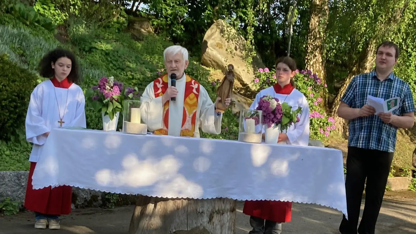 Parrer Andreas Schlagenhaufer mit der Madonna, die er immer bei den Maiandachten dabei hat, mit den Minstrantinnen Johanna und Antonia Schärtl sowie Lektor Mathias Uschold am Altar auf der „Kainzmühl“. (Bild: Josef Schärtl)