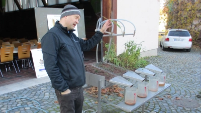 Michael Lukas (Wasserbeauftragter vom AELF) erklärt am Regensimulator, wie sich Starkregenereignisse auf unterschiedliche Böden(bewüchsen) auswirken. (Bild: Valentin Rumpler)