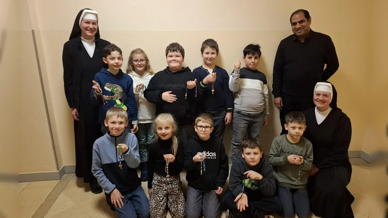 Die Erstkommunionkinder mit Schwester Ancilla (hinten links), Schwester Anne (vorne rechts) und Pfarrer Benny (hinten rechts). (Bild: Stephanie Lederer)