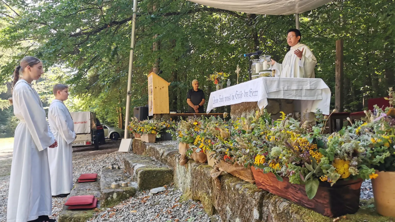 Pater Samuel Patton beim Segensgebet für die Kräuterweihe, vor dem Altar aufgebaut die für die Abholung bereit gestellten Kräuterbüschel.  (Bild: Herbert Ziegler)
