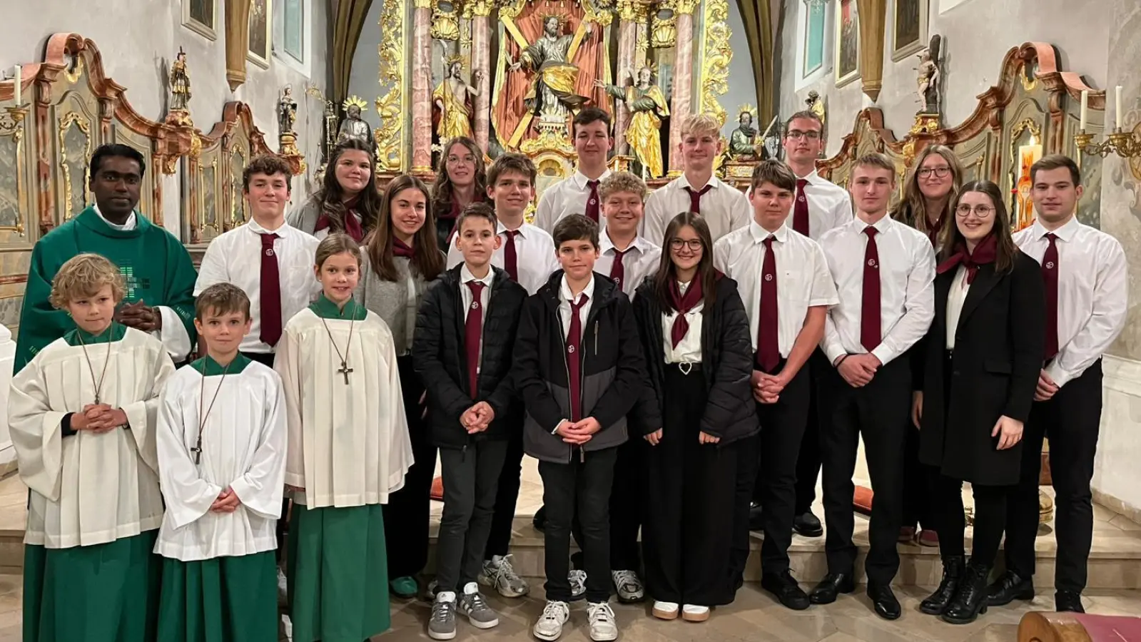 Nach der Messe wurde der Anlass noch mit einem Foto festgehalten. Zu sehen sind die Neu- und Bestandsmitglieder, sowie Pfarrer Savari mit Ministranten. (Bild: Matthias Maderer)