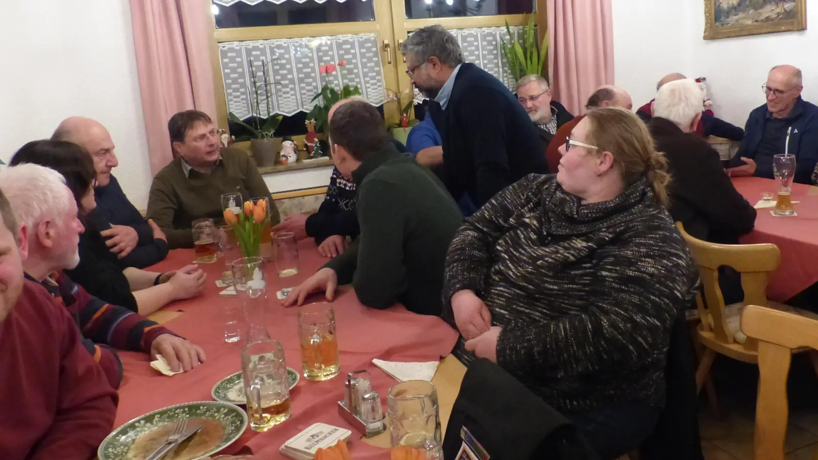 Pater Jo Jovilla Kurian (stehend) und Diakon Ulrich Wabra (rechts davon sitzend) tauschten sich mit den Ehrenamtlichen aus. (Bild: Sieglinde Schärtl)