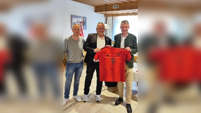 Fanbeauftragter FC Bayern Alexander Groß (links) und Direktor Markus Meindl (rechts) bedankten sich beim Beauftragten und Sprecher des Fandialogs Oberpfalz des FC- Bayern München bei Marcus Fritsch (Mitte), der nach 13 Jahren aufhörte, mit einem Bayern-Trikot mit Unterschriften der aktuellen Mannschaft. (Bild: Marcus Fritsch)
