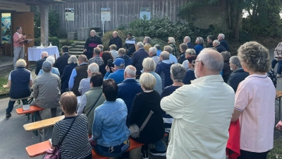 Gabi Eichenseher (am Mikrophon), die Erbauerin der Mühlhofer Kapelle, erläutert Entstehung und Bau der Franziskuskapelle, rechts daneben die Priester Msgr. Thomas Schmid, Pfarrer Markus Nees und Pfarrvikar P. James George. (Bild: Helmut Konrad)