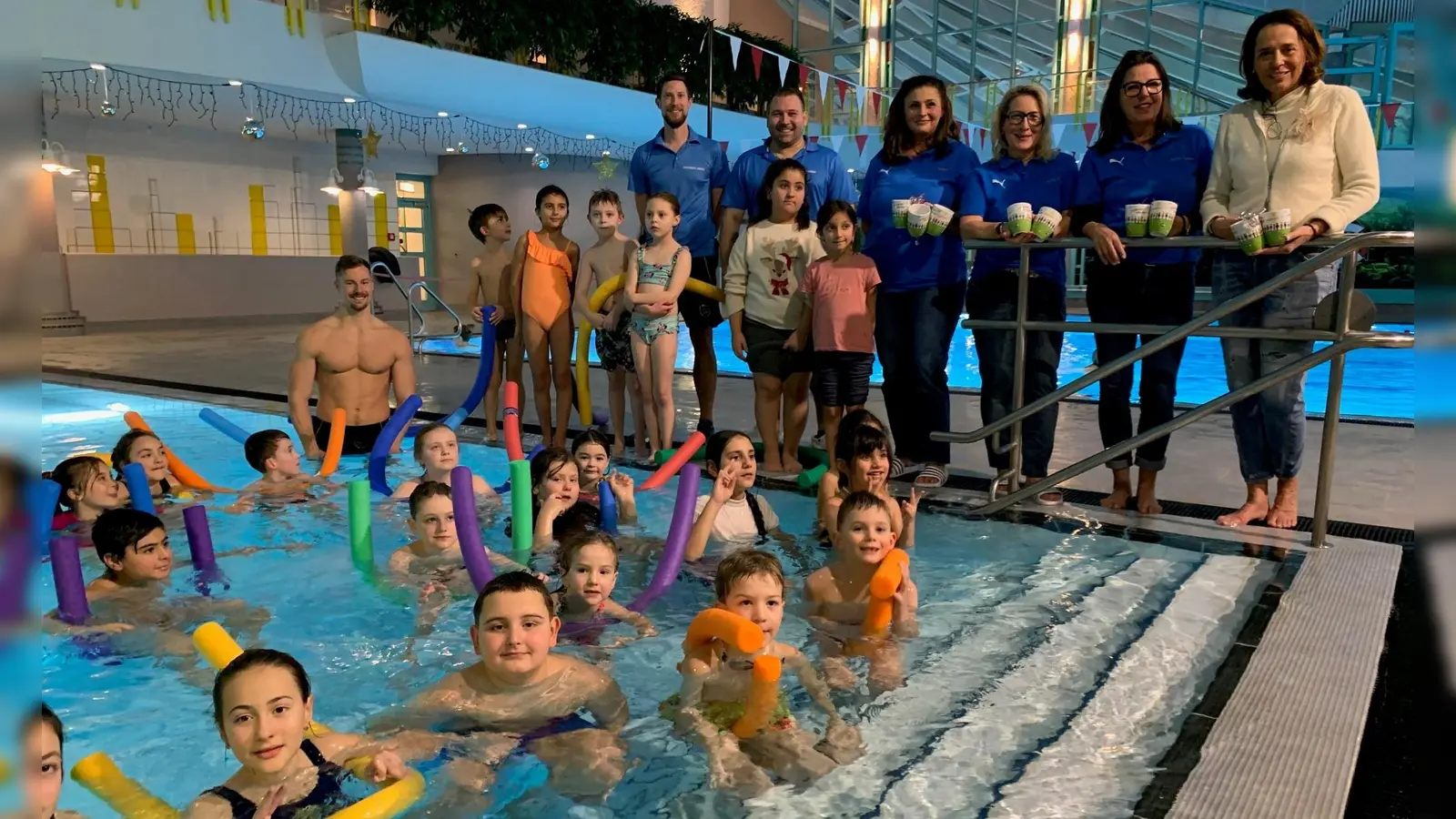 Anne Wagner, Katharina Ostermann, Nevin Yerlihaya und Sandra Drechsler von „Amberger Kinder helfen” (alle von rechts) sowie die Schwimmlehrer Christian Düring, Michael Meier und Andre Schneider (im Wasser) freuen sich zusammen mit den Buben und Mädchen aus verschiedenen Grundschulen über deren bestandenen Schwimmkurs.  (Bild: Thomas Amann)