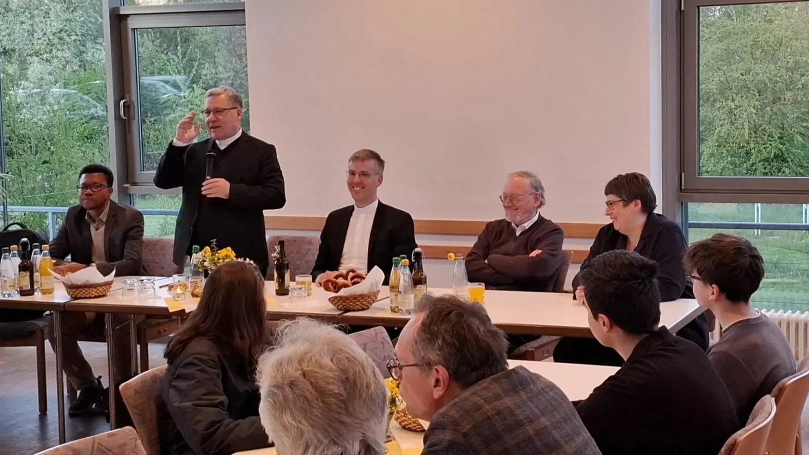 H. H. Regionaldekan Manfred Strigl (stehend) fasst seine Eindrücke der Pastoralvisitation im Pfarrheim zusammen. (Bild: Ernst Wawra)