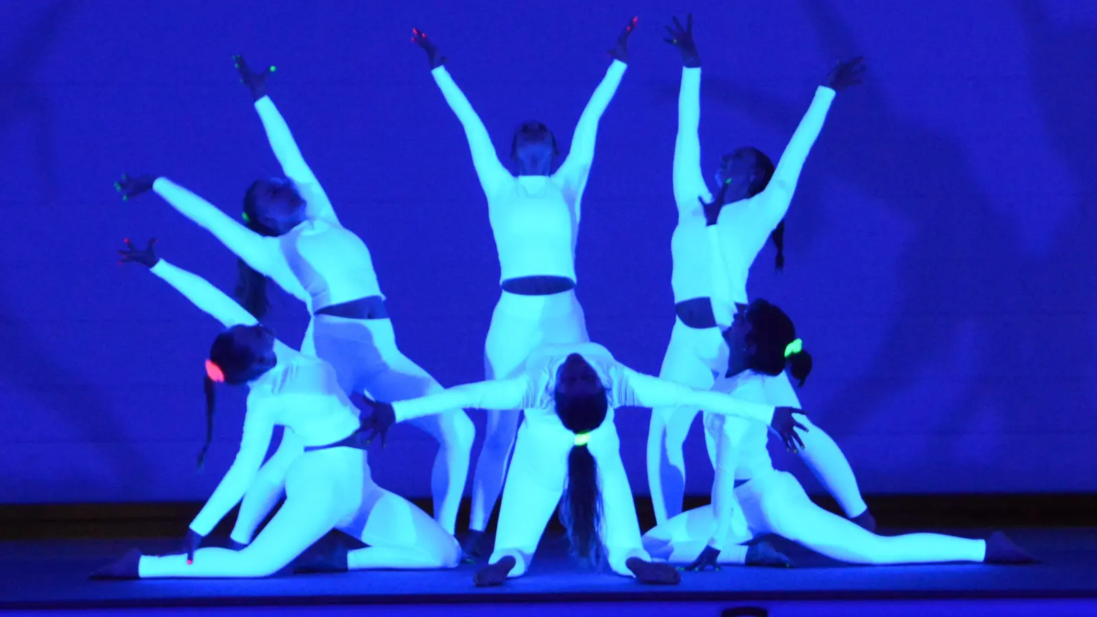 Die Trainerinnen tauchten bei ihrem Auftritt in „Unterwasserwelten“ ab und zeigten bei eindrucksvoller Schwarzlichtbeleuchtung synchrone Akrobatik. (Bild: Melissa Braunreuther)