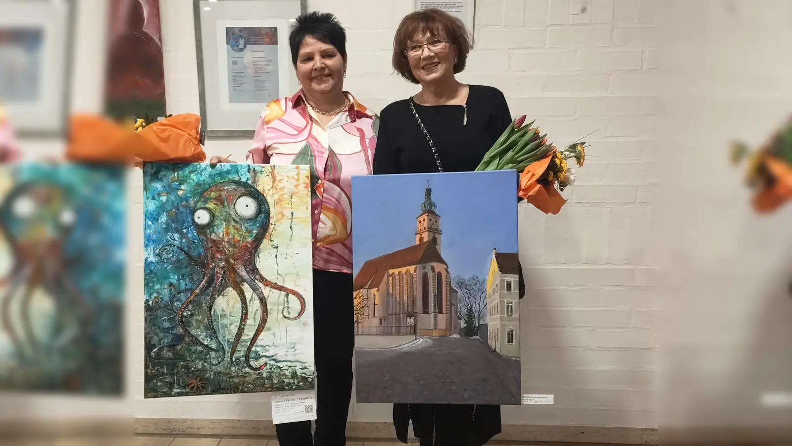 Jetzt hängen auch diese Bilder an den Wänden im St. Anna Krankenhaus, die Simone Reiche (links) und Galina Burdeinaja-Peter hier noch den Besuchern der Vernissage präsentieren. (Bild: Ute Büttner)