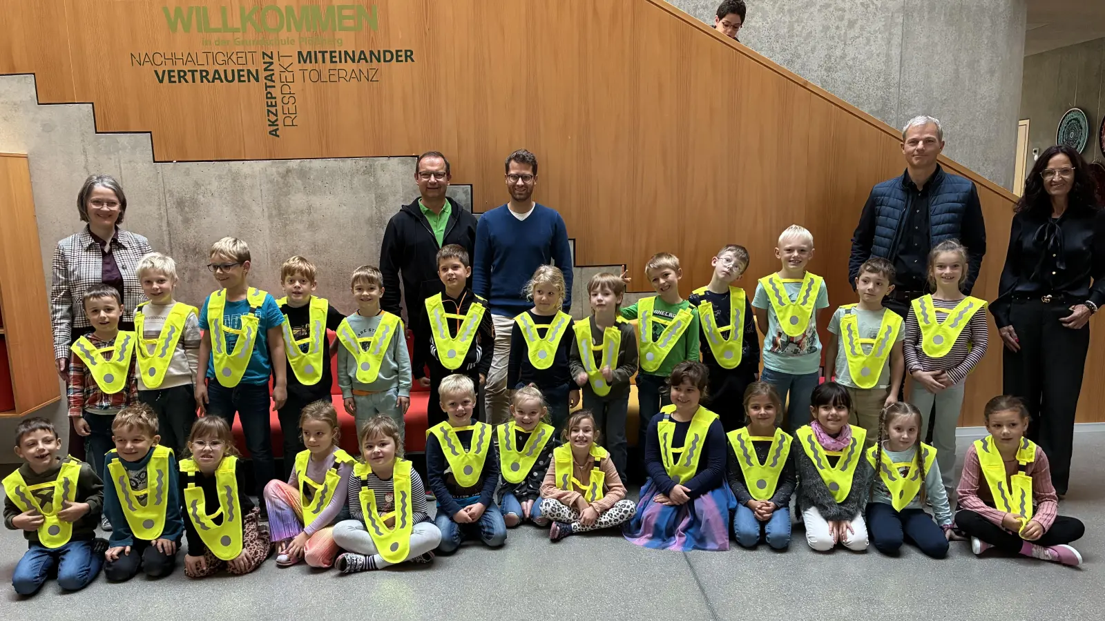 Die Erstklässler der GS Plößberg sind begeistert von den „Sicherheitsüberwürfen“. Mit ihnen freuen sich v.li: Puff Martina/Schulamtsdirektorin, Jaspers Jürgen/Kreisverkehrswacht, Konrad Alexander/Sicherheitsbeauftragter der Grundschule, Spickenreuther Matthias/AOK, Dippel Diana/Rektorin (Bild: Corinna Schmeller)