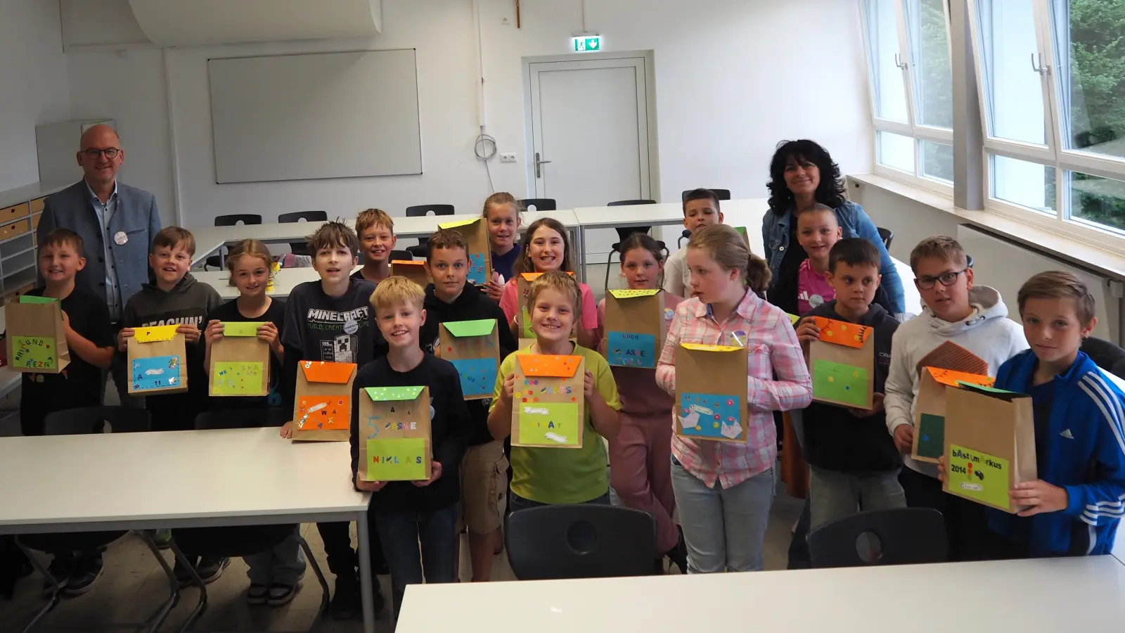 Eine bleibende Erinnerung: Die künftigen Fünftklässler freuen sich über ihre selbstgebastelten Schultüten und persönlichen Buttons – ein kleiner Vorgeschmack auf den neuen Schulalltag. (Bild: Erni Bühl)