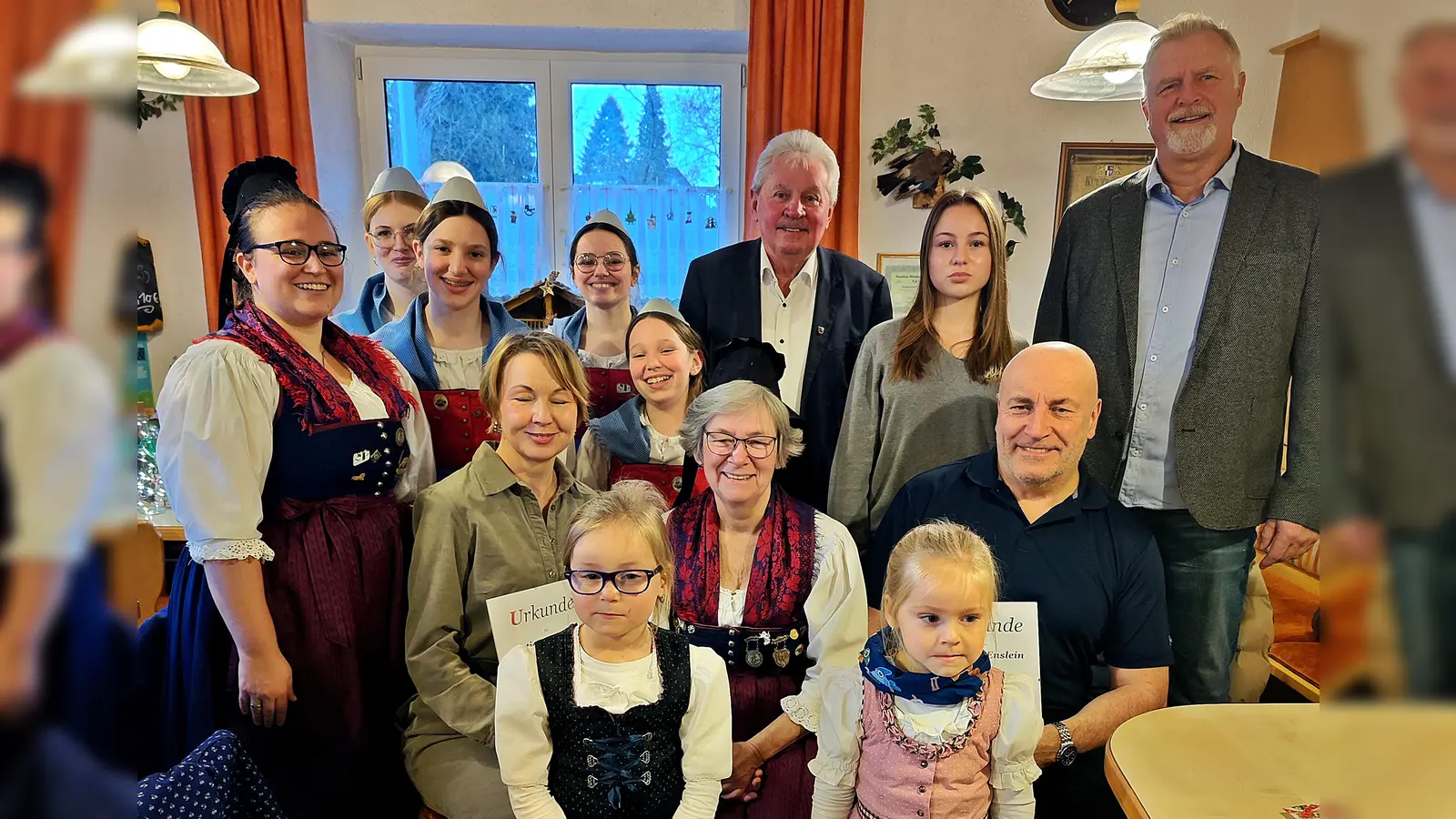 Beim Erinnerungsfoto rückten die Geehrten, Ehrengäste und die Jugendgruppe lächelnd zusammen – ein Bild des Zusammenhalts. Links Tatjana Enslein mit Urkunde, in der Mitte Vorsitzende Christa Binner und rechts Johann Enslein sitzend. (Bild: Hans Forster)