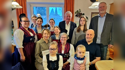 Beim Erinnerungsfoto rückten die Geehrten, Ehrengäste und die Jugendgruppe lächelnd zusammen – ein Bild des Zusammenhalts. Links Tatjana Enslein mit Urkunde, in der Mitte Vorsitzende Christa Binner und rechts Johann Enslein sitzend. (Bild: Hans Forster)