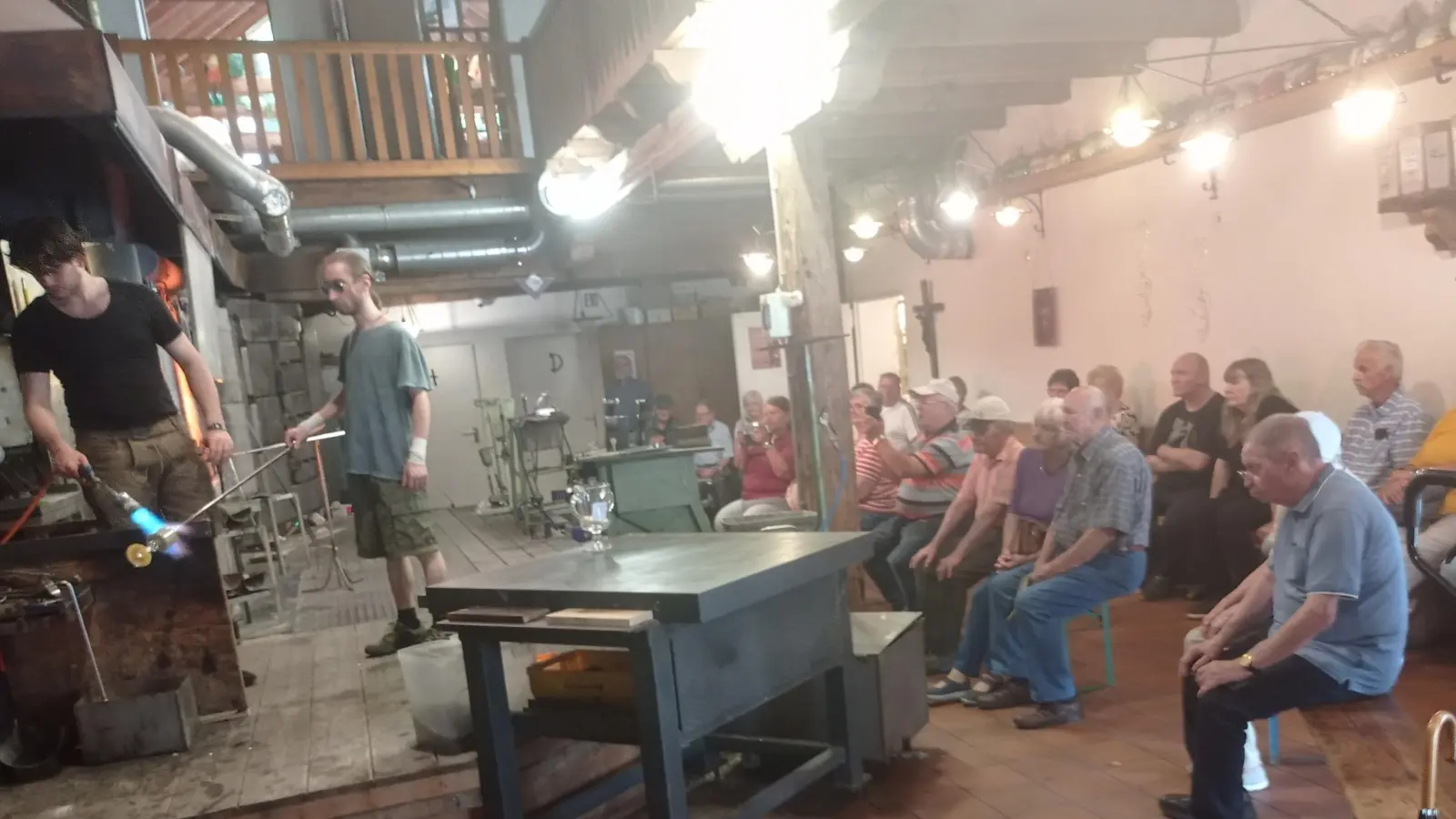 Zwei junge Glasbläser bei Vorführung und Erläuterung vor der Gruppe des Wandervereins Kemnath im Glasdorf Weinfurtner in Arnbruck. (Bild: Anton Heindl )