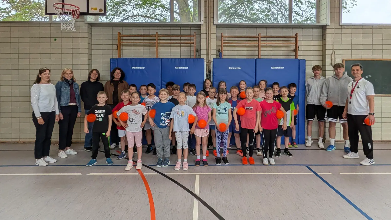 Mitglieder der Frauenunion Moosbach übergeben 30 Minihandbälle an die Schüler und die Schulleitung der Grundschule. Mit auf dem Bild sind drei Handballtrainer vom Ortenburg-Gymnasium Oberviechtach. (Bild: Miriam Höcherl)