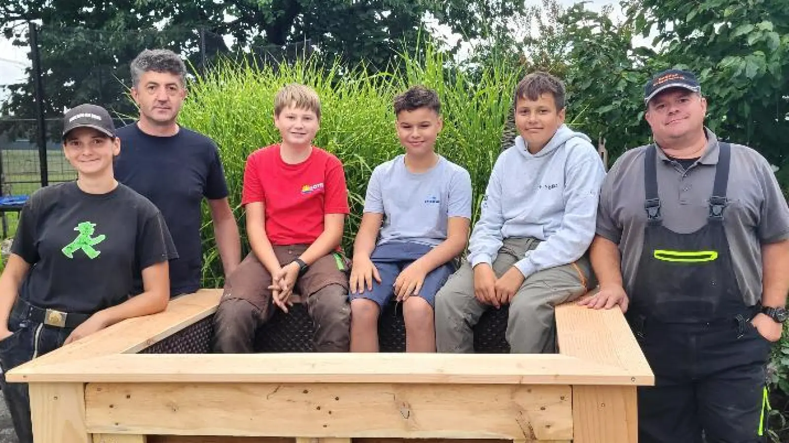 Die Jugendlichen präsentieren stolz das fertige Hochbeet (Bild: Maria Treiber)