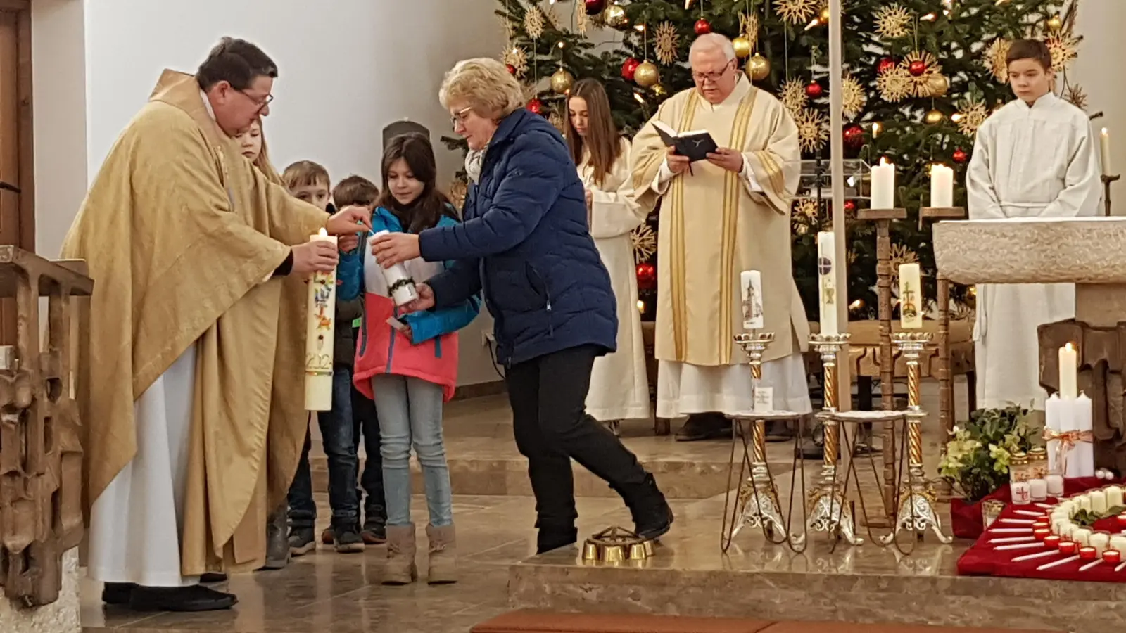 Viele Besucher waren zum Familiengottesdienst mit Lichtmessfeier und Blasiussegen in die Pfarrkirche gekommen. Die Kinder durften von der Osterkerze Lichter an verschiedenen Kerzen anzünden. Unterstützt wurden sie von PGR-Sprecherin Elisabeth Völkl.<br> (Bild: Peter Garreiss)