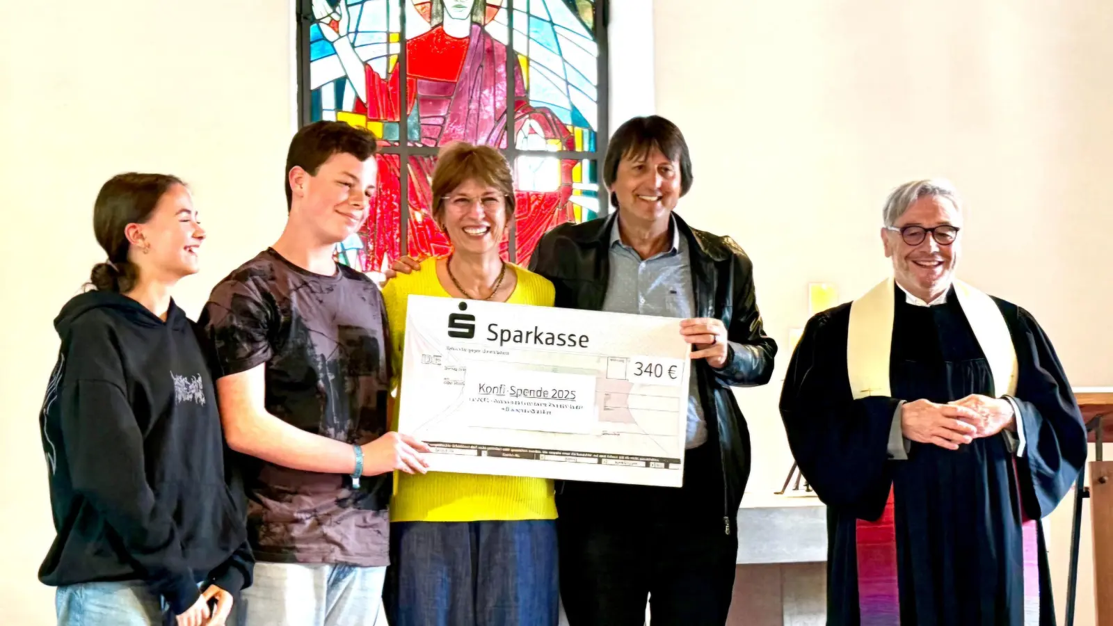 Ein Höhepunkt des Gottesdienstes ist die Übergabe eines symbolischen Schecks durch Pfarrer Klaus Stolz (rechts) und zwei Konfirmierte (links) an das Pfarrerehepaar Milton Jandrey ud Márcia Hülle (Mitte). (Bild: Brigitte Lang)