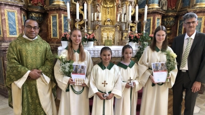 Die neuen und die für ihren langjährigen Dienst geehrten Ministrantinnen (v. li. Lea Rittner, Namira Lindner, Sofia Graf und Susanne Ratzke) mit Pater Jimmy und Mesner Werner Rieger. (Bild: Christian Trummer)