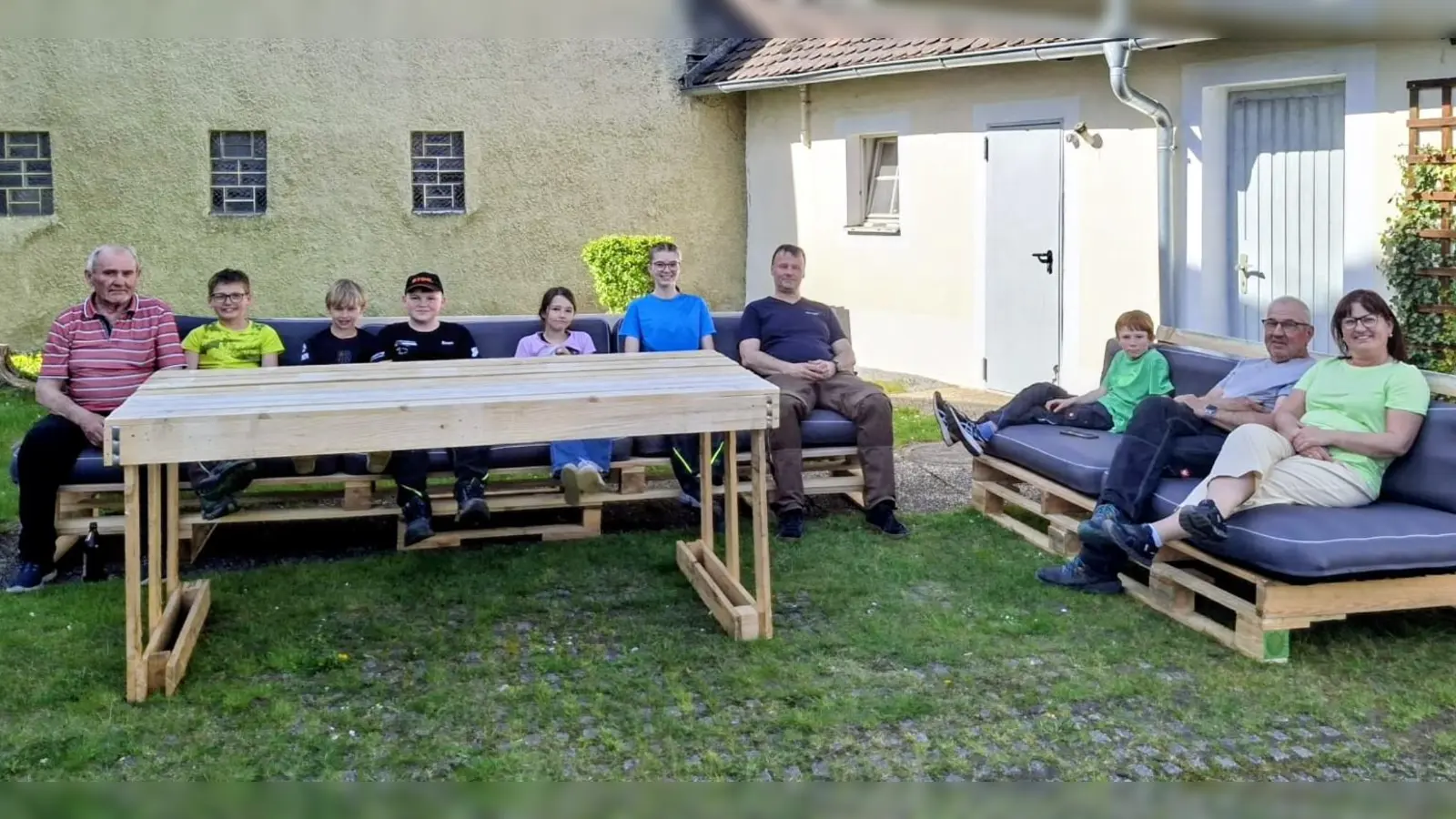 Die Ministranten und ihre Helfer bei der ersten Sitzprobe auf der selbstgebauten Paletten-Lounge im Pfarrgarten. (Bild: Bianca Rappl)