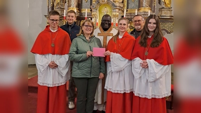 Petra Teichner, Vorsitzende der Kolpingsfamilie Neunkirchen übergibt eine Spende an unsere Oberministrantinnen und Oberministranten im Beisein von Pfarrvikar Robert und Kirchenpfleger Willi Fuchs. (Bild: Karin Rittner)