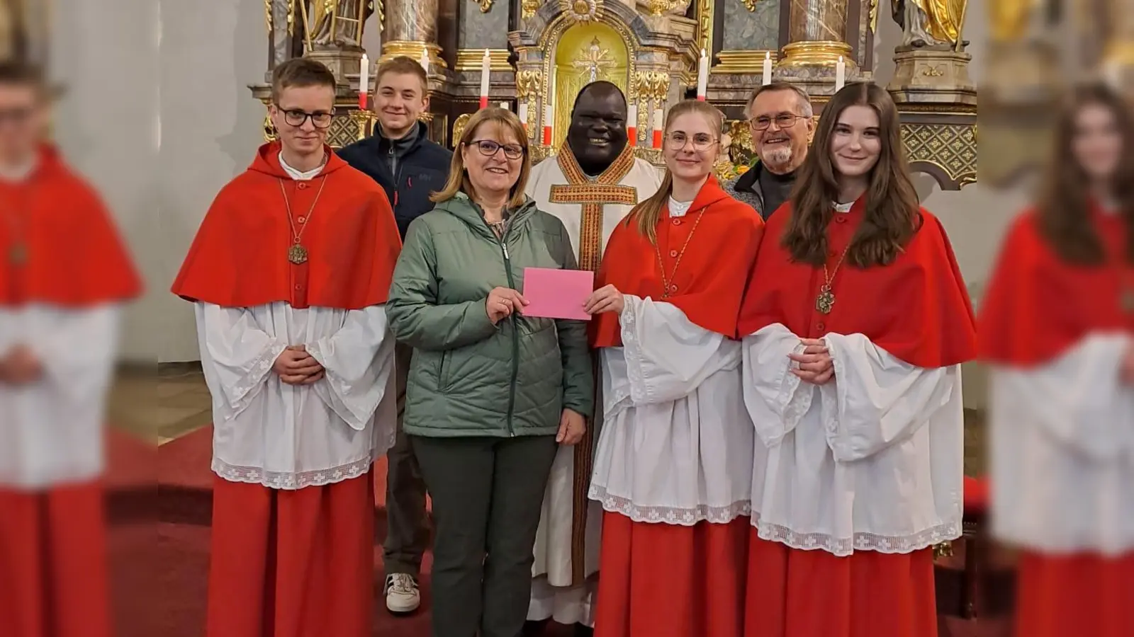 Petra Teichner, Vorsitzende der Kolpingsfamilie Neunkirchen übergibt eine Spende an unsere Oberministrantinnen und Oberministranten im Beisein von Pfarrvikar Robert und Kirchenpfleger Willi Fuchs. (Bild: Karin Rittner)