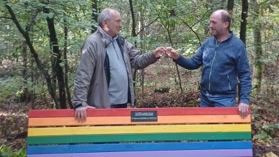Gunter Hannig (links) und Reinhold Stock stoßen auf die neue Bank des Oberpfälzer Waldvereins, Zweigverein Weiden, an.  (Bild: Ursula Breinbauer )