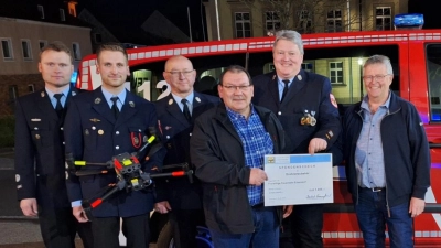 Bernhard bauernfeind (4.v.l.) überreicht einen symbolischen Spendenscheck an Kommandant Bernhard Schmidt (5.v.l.). Mit beiden freuen sich (v.l.) Feruerwehrvorsitzender Daniel Grünbauer, Bastian Kaiser (Leiter der Drohnengruppe), Wolfgang Gruber (stellvertretender Kommandant) und Rauchclubkassier Peter Tretter. (Bild: Fabian Keppler-Stobrawe)