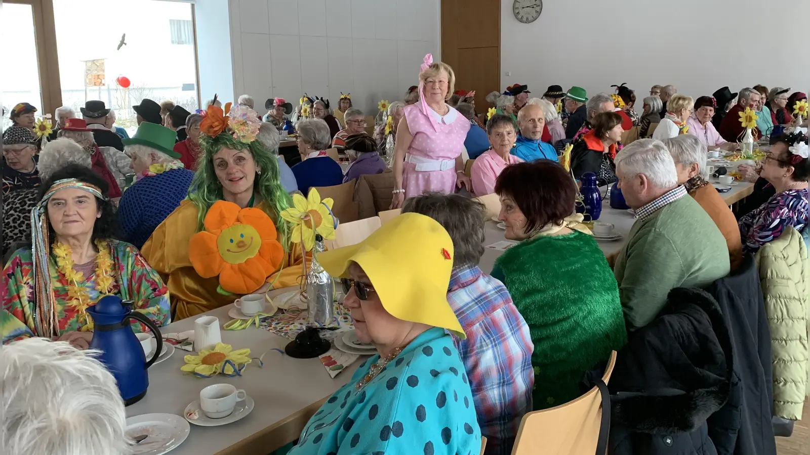 Über 100 Senioren mit ihrer Seniorenbeauftragten Gabriele Beck (stehend) im Saal bunt maskiert und in bester Stimmung  (Bild: Silvia Beck)