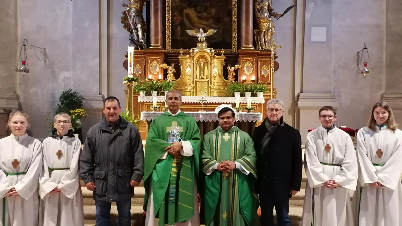 Pater Antony Mathew und Pfarrer Martin (Bildmitte links und rechts) mit Pfarrgemeinderatssprecher Horst Straub (Dritter von links) und Kirchenpfleger Wolfgang Braun (Dritter von rechts) und den Ministranten (Bild: Michaela Staufer)