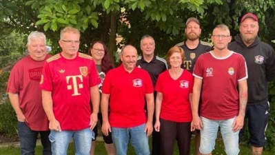 Markus Hartmann (ganz vorne rechts in rot) ist jetzt der 2. Vorstand des FC Bayern Fanclub Neustadt. Er und der versammelte Ausschuss werden künftig die erste Vorsitzende Carolin Washausen (vorne rechts) unterstützen. (Bild: Miriam Troppmann)