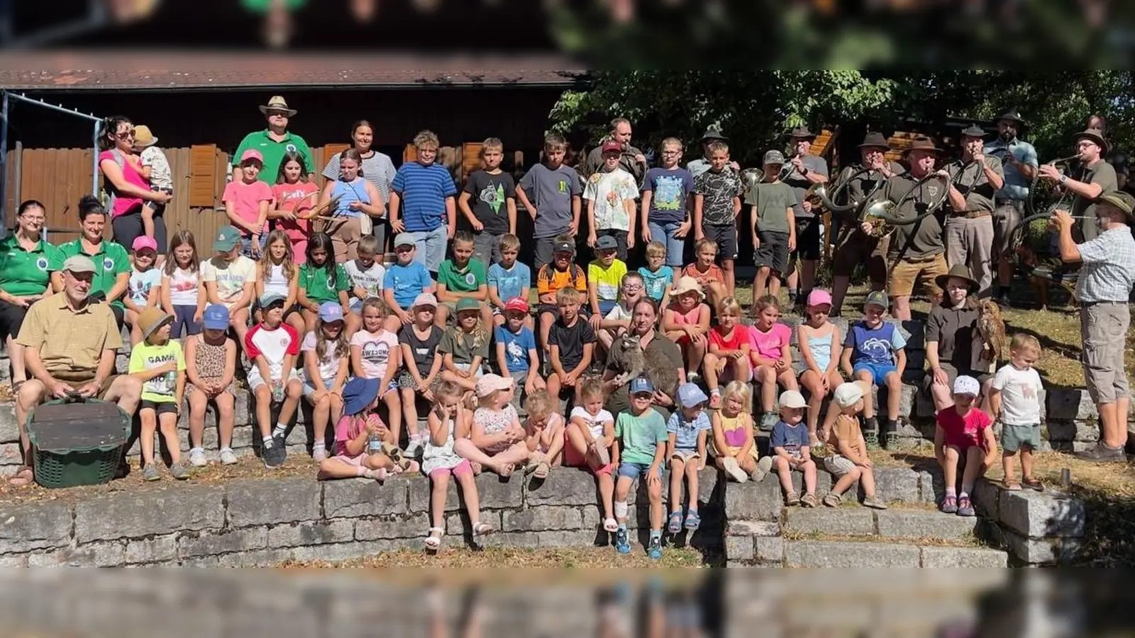 Die Kinder mit den Jagdhornbläsern unter der Leitung von Hornmeister Eduard Forster (stehend, vorne rechts außen). Erster Vorsitzender Peter Kirner (oben, Zweiter von links) freute sich über den erfolgreichen Nachmittag. Ihm ist die Jugendarbeit und die Mitgliedergewinnung bei Familien stets eine Herzensangelegenheit. (Bild: Albert Winter)