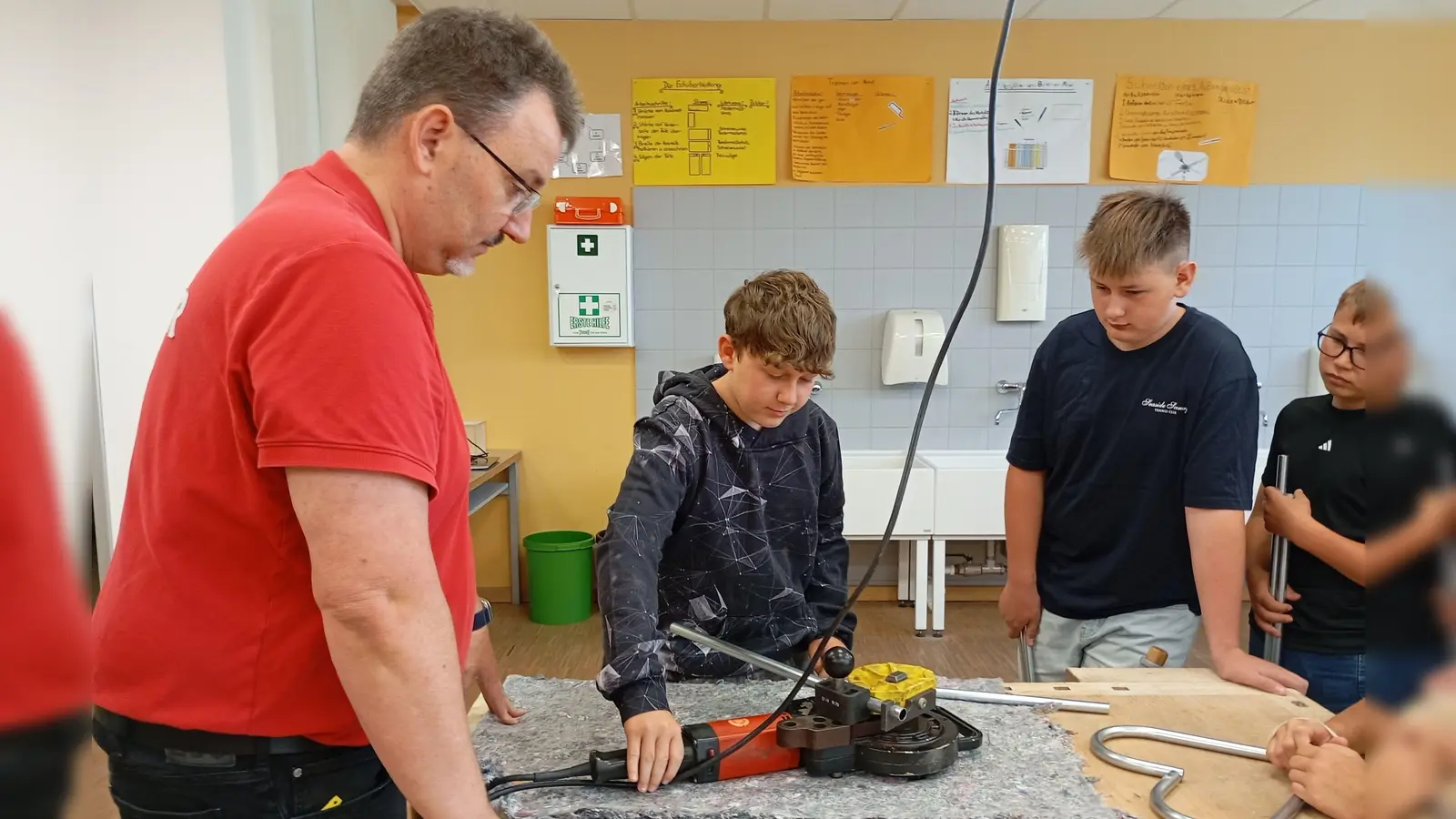 Nach dem kurzweiligen theoretischen Input durften die Schülerinnen und Schüler selbst Hand angelegen: gemeinsam mit Andreas Lotter (links) wurde ein Dekoherz aus Leitungsrohren gebaut.  (Bild: Marina Schießl )