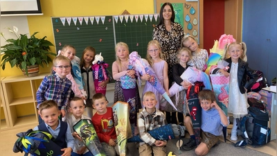 Mit Freude und Stolz präsentieren die Mädchen und Buben ihre Schultüten nach der ersten Schulstunde ihrer Lehrerin Sophie Wittmann (Bild: Sieglinde Schärtl)
