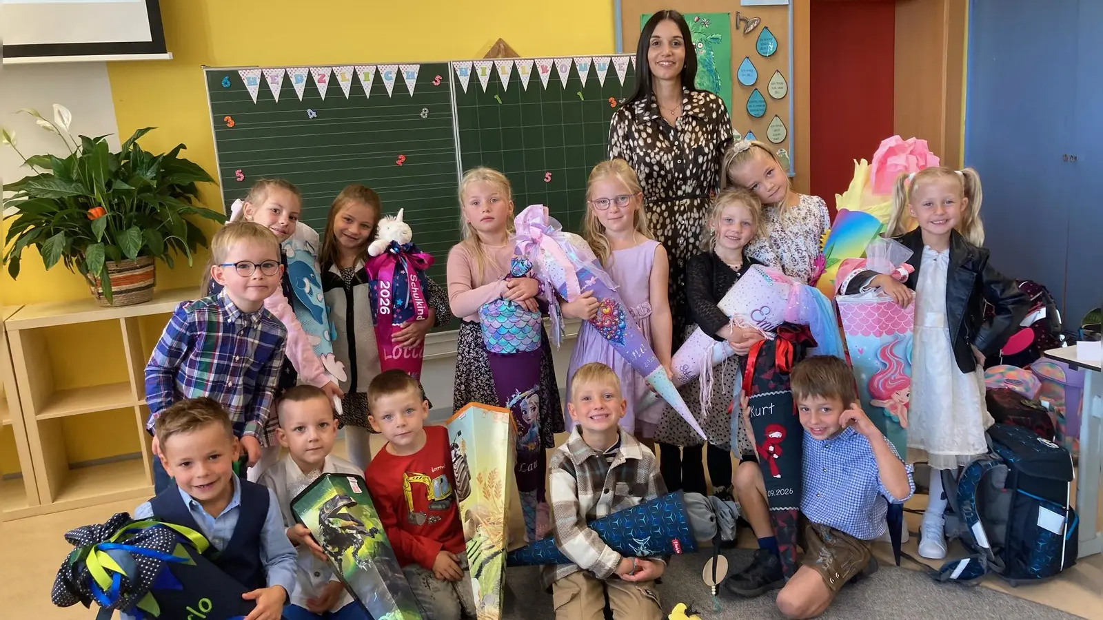 Mit Freude und Stolz präsentieren die Mädchen und Buben ihre Schultüten nach der ersten Schulstunde ihrer Lehrerin Sophie Wittmann (Bild: Sieglinde Schärtl)