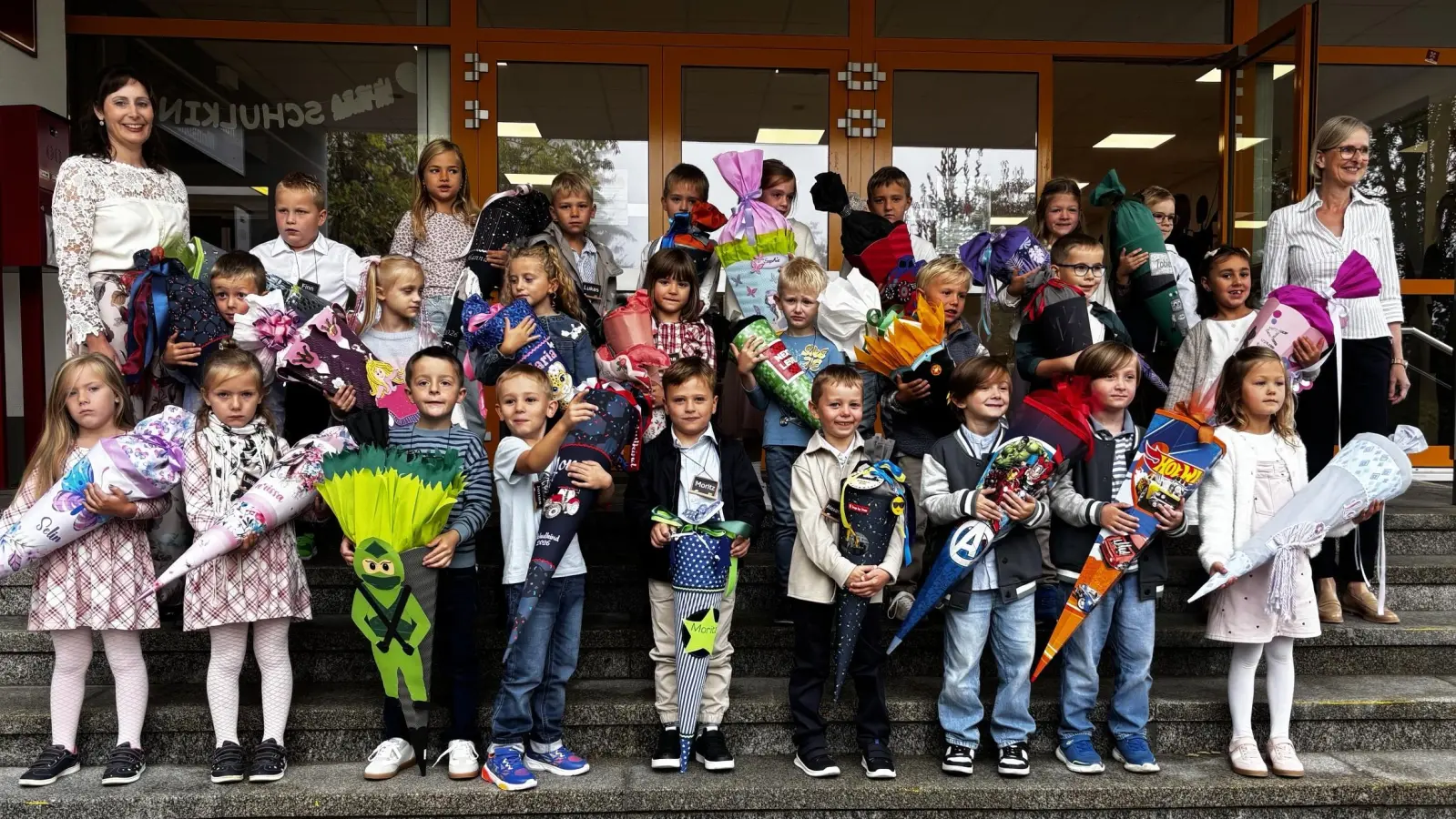 25 Erstklässler mit Klassenlehrerin, Frau Susanne Staudinger, und Schulleiterin, Frau Birgit Enders (Bild: Rita Flierl)