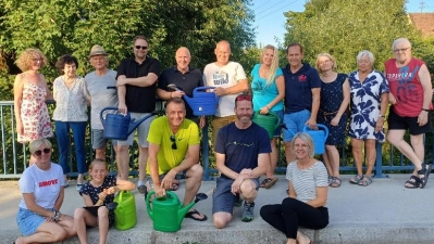 Anwohner des Ortsteils Haidhof bewässern auch in diesem Jahr wieder die Brücke in der Max-Reger-Straße. Das freut die Initiatoren Uwe Bergmann und Harald Kausler (vorne Mitte) sowie Bürgermeister Marcus Eichenmüller (hinten, Fünfter von links). (Bild: David Bergmann)