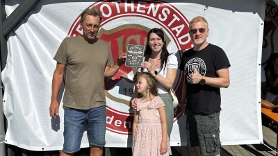 Die Tanzgruppentrainerin Alexandra Genov überreicht eine originelle Erinnerungsplakette an Abteilungsleiter Stefan Heimerl (links). Rechts im Bild 2. Vorsitzender Roland Richter. (Bild: Elena Heimerl)