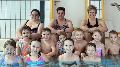Helferin Tanja Schedl, Trainerin Claudia Reindl und Trainerin Andrea Kien (hinten, von links) lernten den Kindern den Bewegungsablauf des Brustschwimmens (Bild: DLRG Stiftland/Christina Kien/exb)