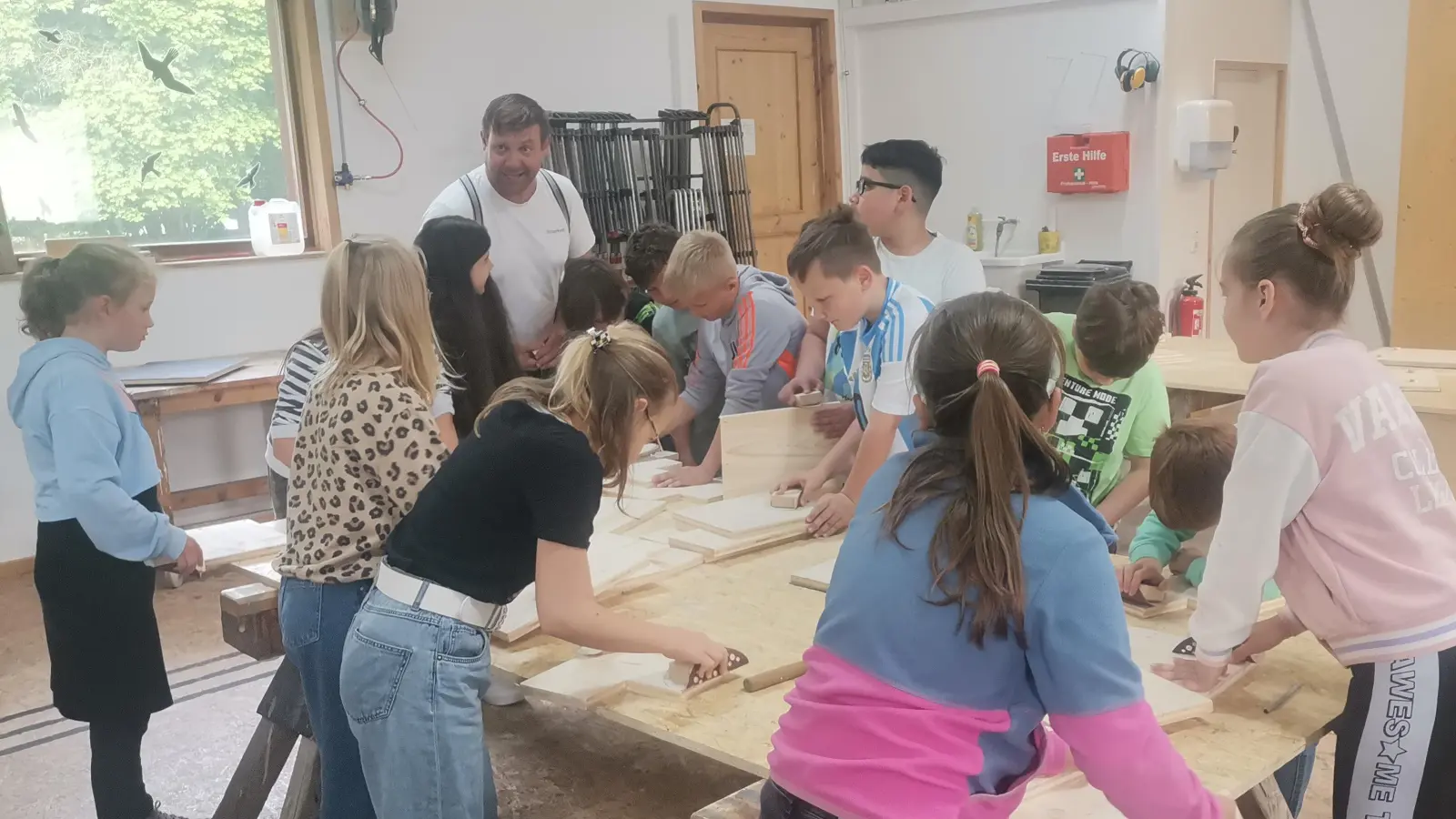 Unter Anleitung von Zimmerermeister Stefan Killermann (hinten) machten sich die Buben und Mädchen an die Arbeit. (Bild: Annemarie Mösbauer)