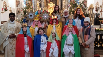 Auf dem Bild sind Pater Arul links und Kirchenpflegerin Gabi Hawranek rechts. In der Mitte die zwölf ausgesendeten Sternsinger für die Bereiche rund um Pullenreuth. (Bild: Gabi Hawranek )